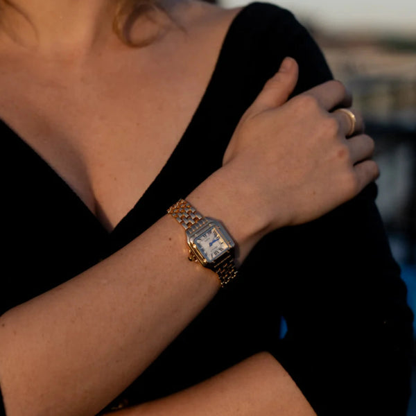 Leonie – Goldene Uhr mit quadratischem Gehäuse.